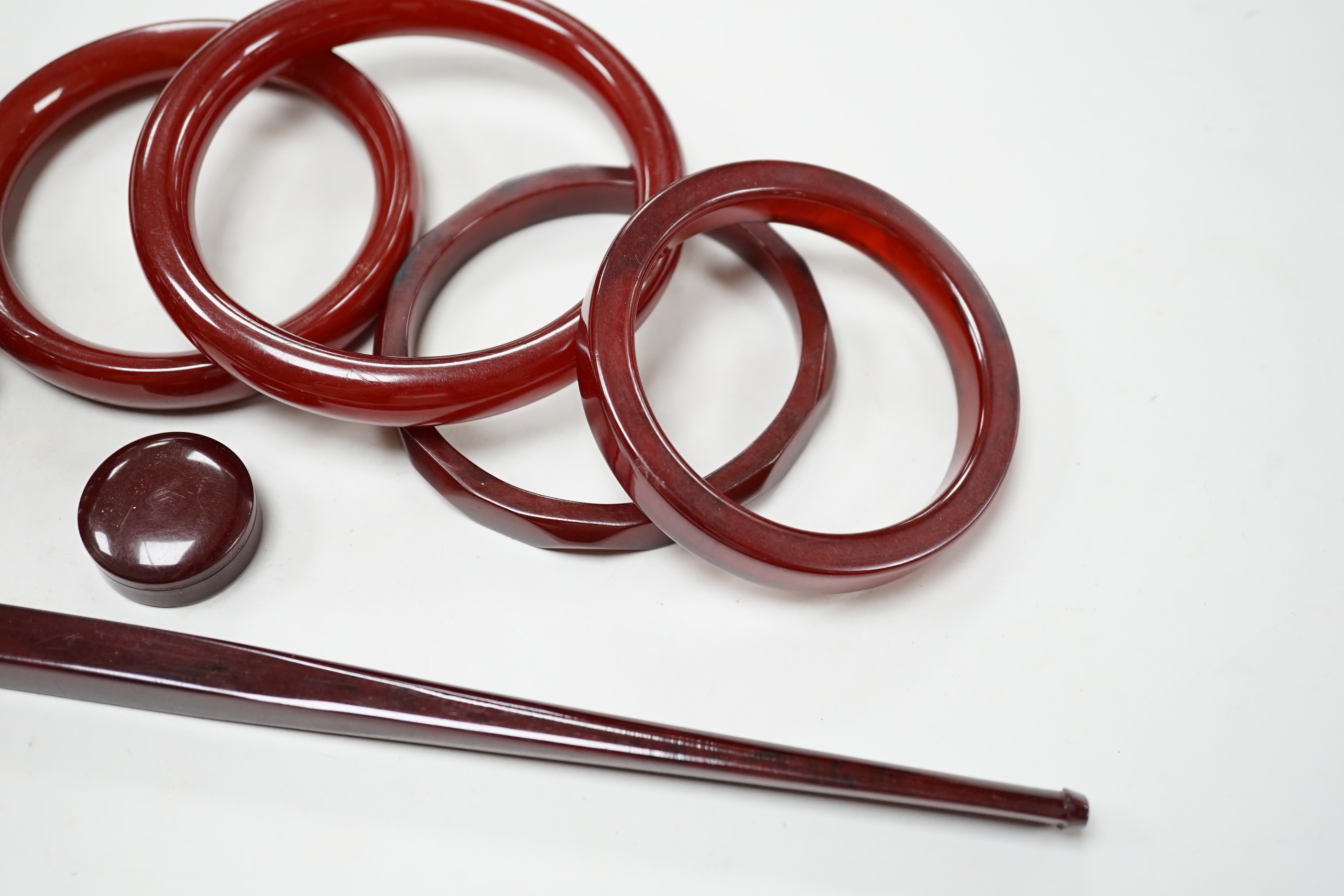 Eight simulated cherry amber items including four bangles and two bracelets.